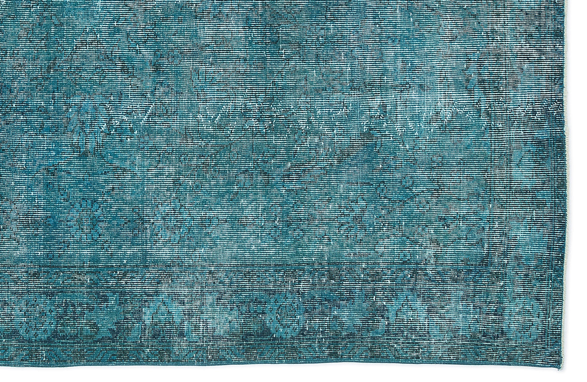 Teal and dark blue distressed rug with a faded traditional medallion pattern on a white background.
