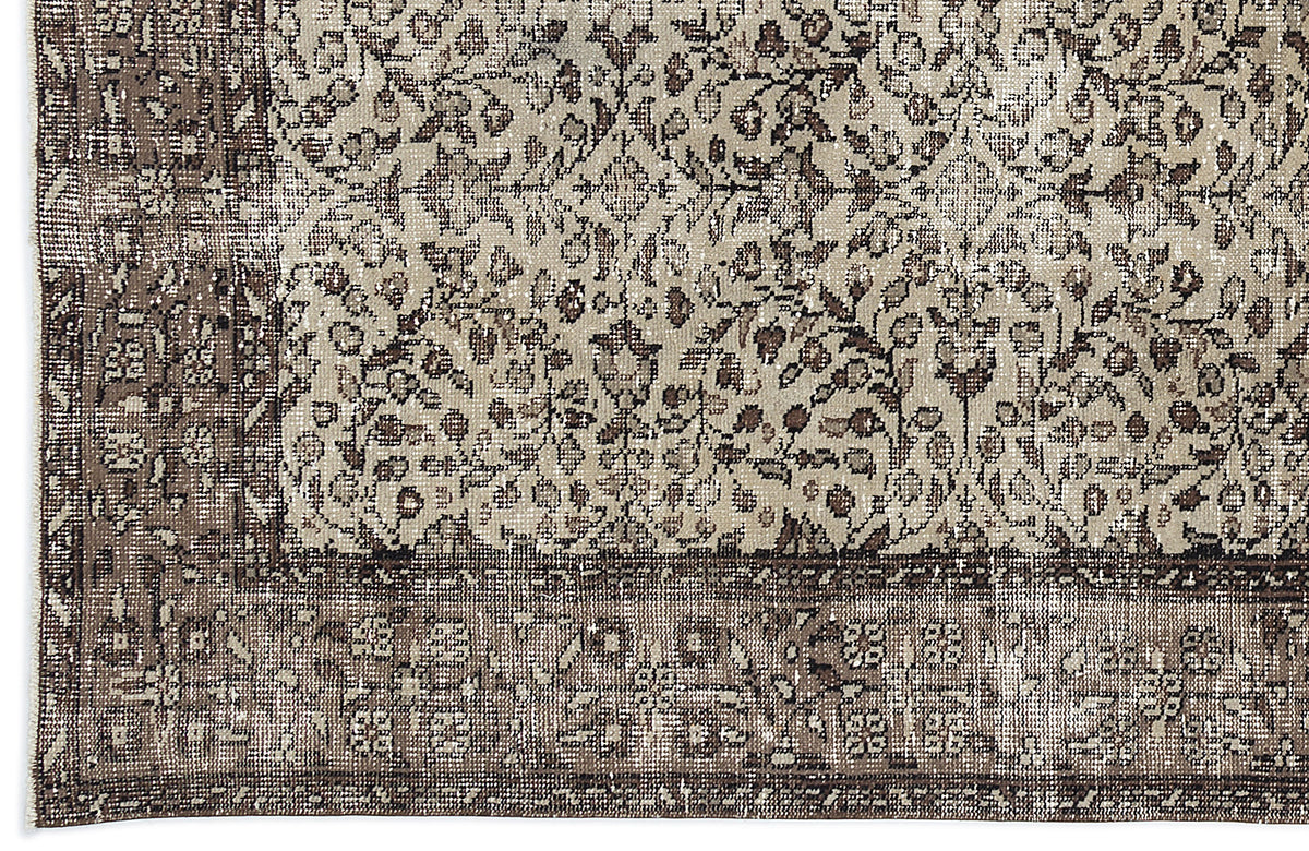 Beige and dark brown distressed rug with a traditional floral medallion pattern and a wide decorative border.