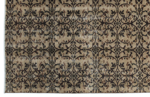 Load image 1 in gallery view. Tan and brown vintage-style rug with a repeating dark floral vine and medallion pattern.