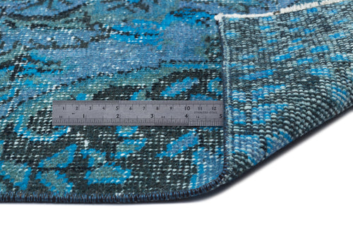 Load image 1 in gallery view. Blue and black distressed pattern rug with a folded corner and a stainless steel ruler for scale on a white background.