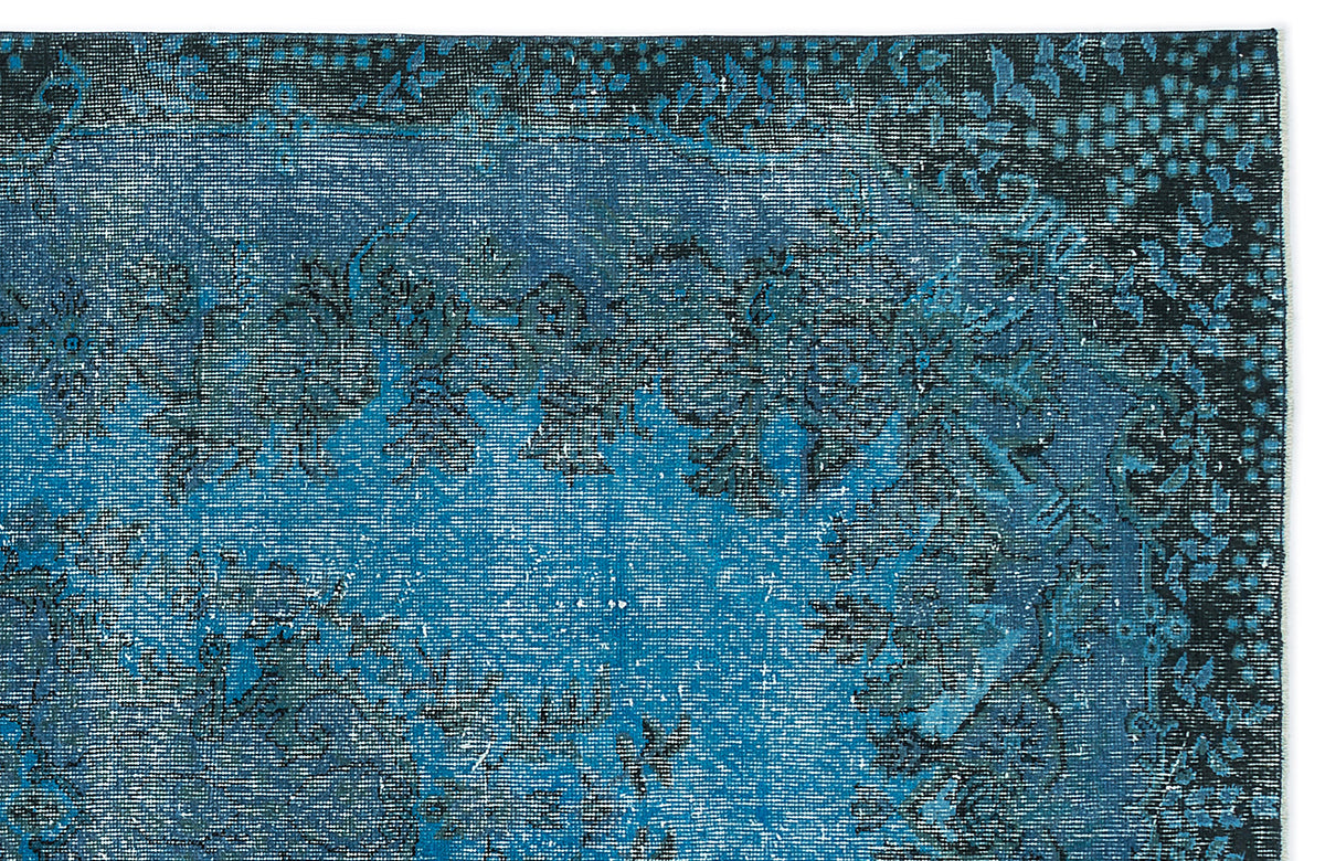 Deep blue and black distressed traditional rug with a faded floral medallion pattern.