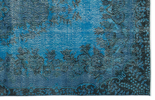 Load image 1 in gallery view. Distressed blue and black rug with a traditional floral medallion pattern and a dark decorative border.
