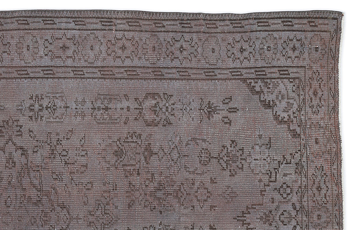 Charcoal grey vintage-style rug with a distressed geometric border and central floral medallion pattern.