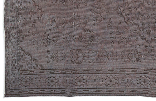 Load image 1 in gallery view. Dark brown vintage-style rug with a faded traditional floral medallion pattern and a geometric border.