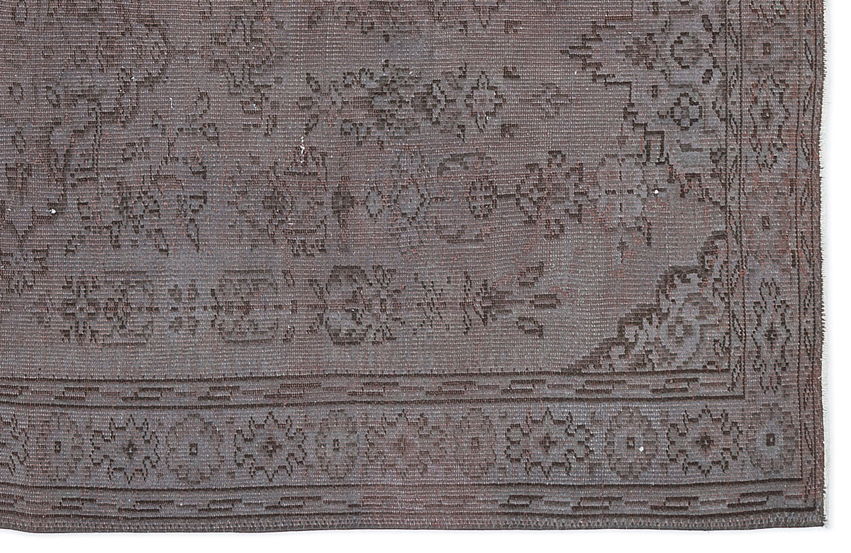 Dark charcoal grey rug with a distressed traditional floral medallion pattern and a geometric border.