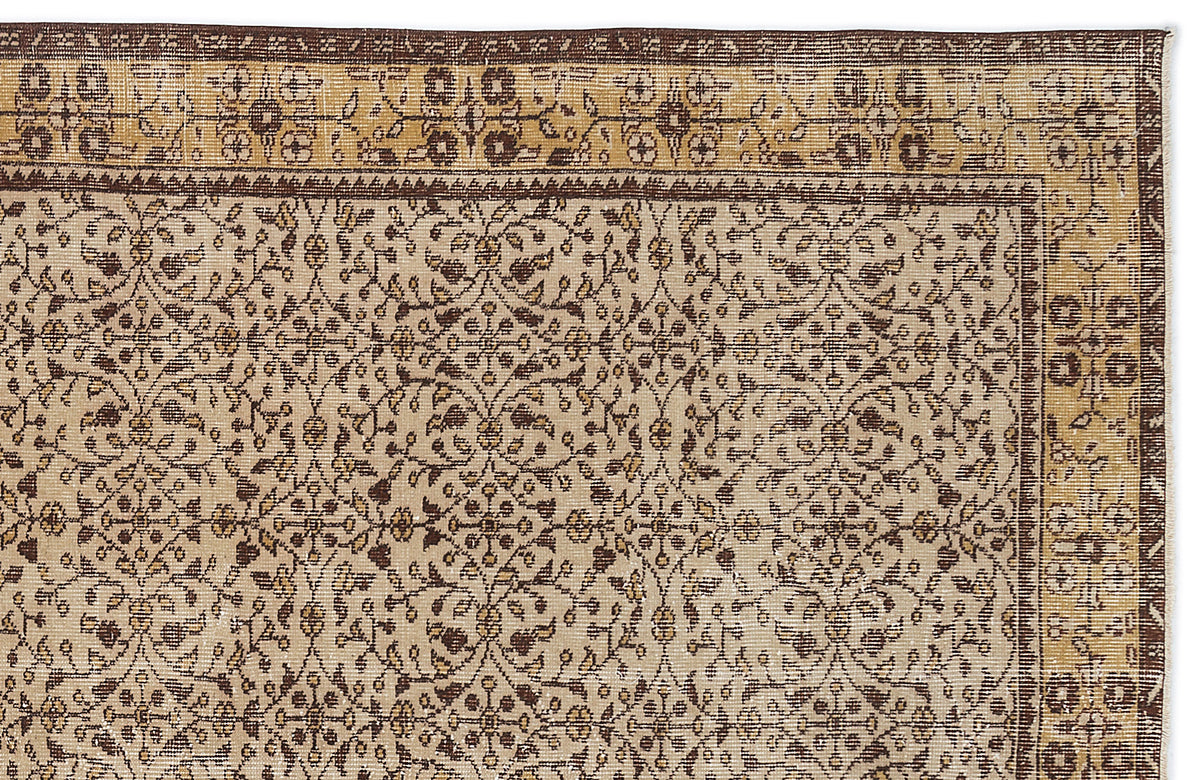 Beige and brown traditional rug with a repeating floral vine pattern and a decorative geometric border.