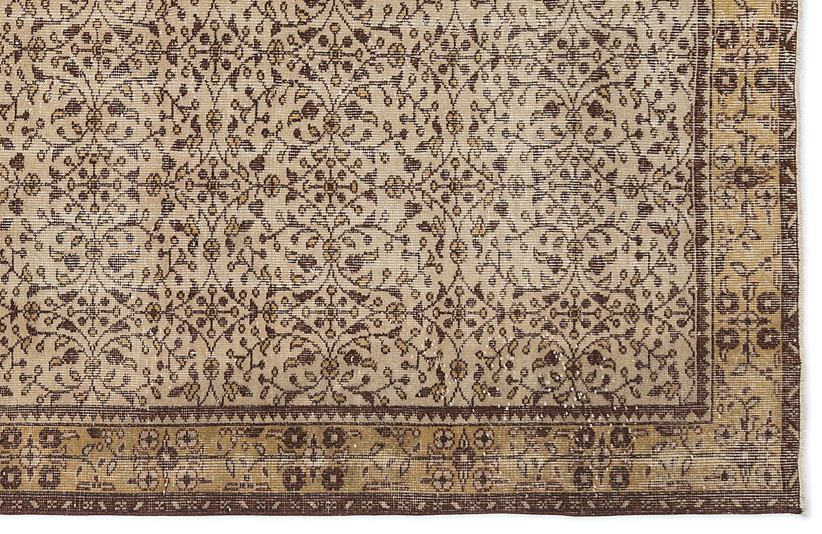 Beige and brown vintage-style rug with a repeating floral vine pattern and a decorative border.