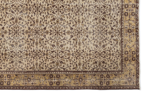 Load image 1 in gallery view. Beige and brown vintage-style rug with a repeating floral vine pattern and a decorative border.