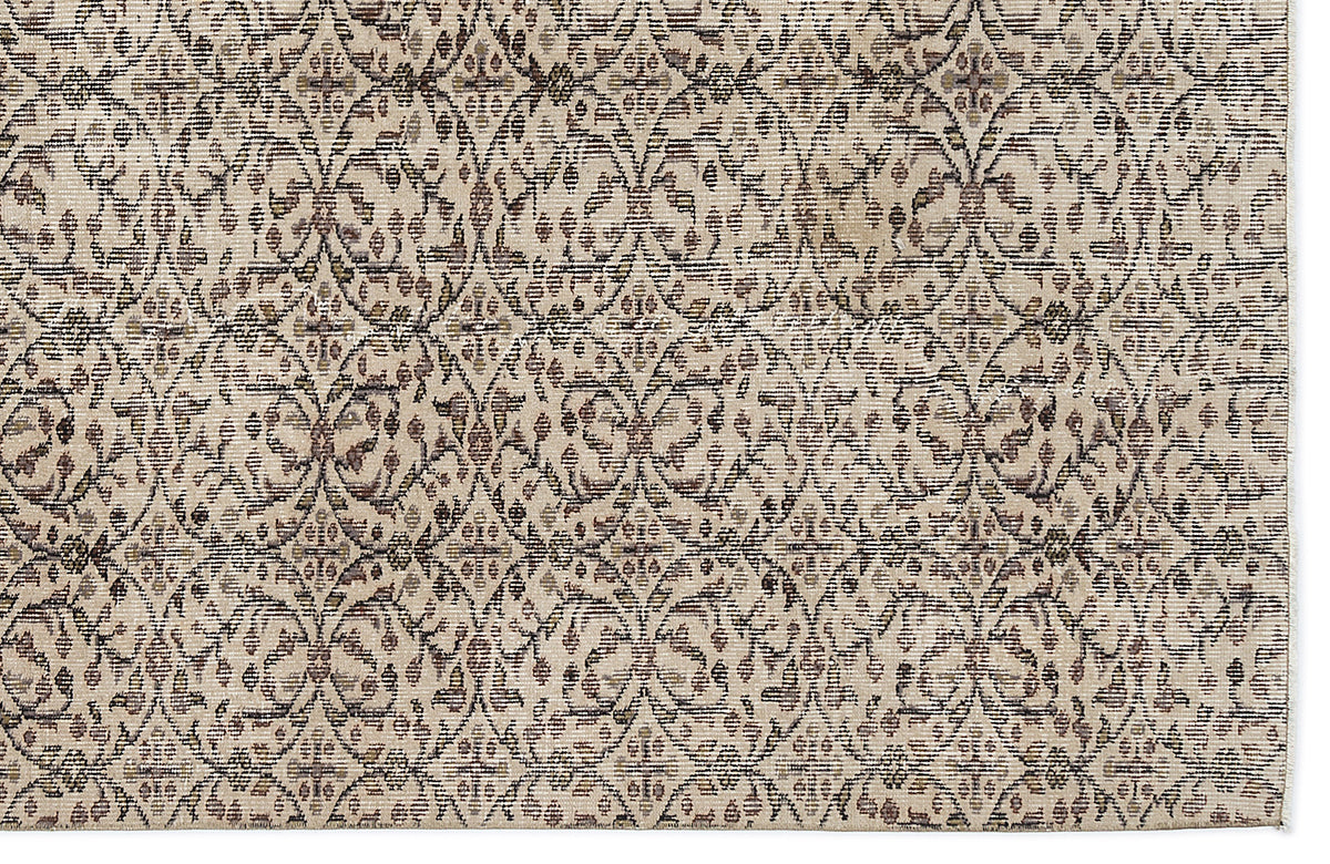 Beige and brown rug with a repeating distressed floral medallion pattern in a lattice arrangement.
