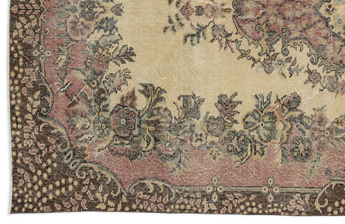 Load image 1 in gallery view. Distressed beige rug with a dark brown border and a faded floral medallion pattern in muted pink, green, and charcoal.