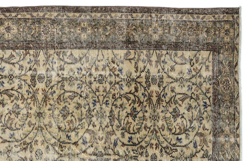 Load image 1 in gallery view. Distressed beige rug with a dark brown border and intricate floral vine pattern in muted blue, green, and brown tones.