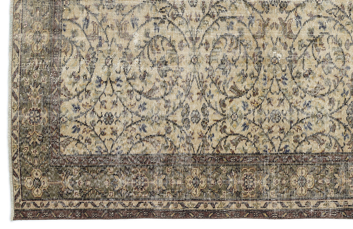 Beige and olive green vintage-style rug with a distressed floral medallion pattern and a dark brown border.