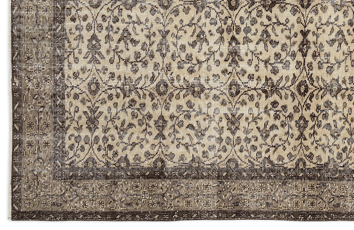 Beige and dark brown rug with a distressed traditional floral medallion pattern and a wide decorative border.