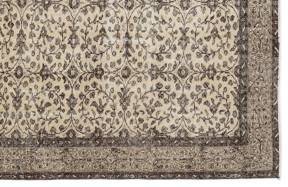 Beige and dark brown traditional rug with a repeating floral vine pattern and a wide decorative border.