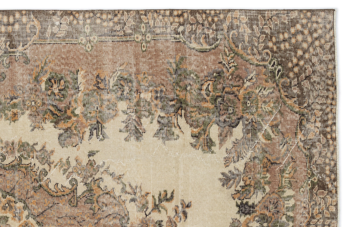 Distressed beige, brown, and sage green rug with a traditional floral medallion pattern on a white background.