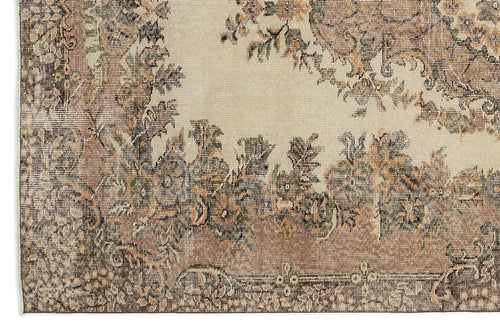 Load image 1 in gallery view. Beige rug with a distressed floral medallion pattern in muted brown, olive green, and charcoal tones.