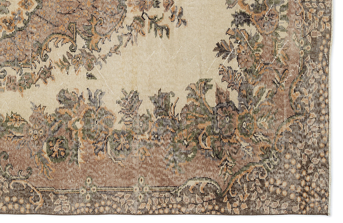 Beige rug with a distressed traditional floral medallion pattern in shades of brown, olive green, and charcoal.