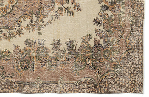 Load image 1 in gallery view. Beige rug with a distressed traditional floral medallion pattern in shades of brown, olive green, and charcoal.