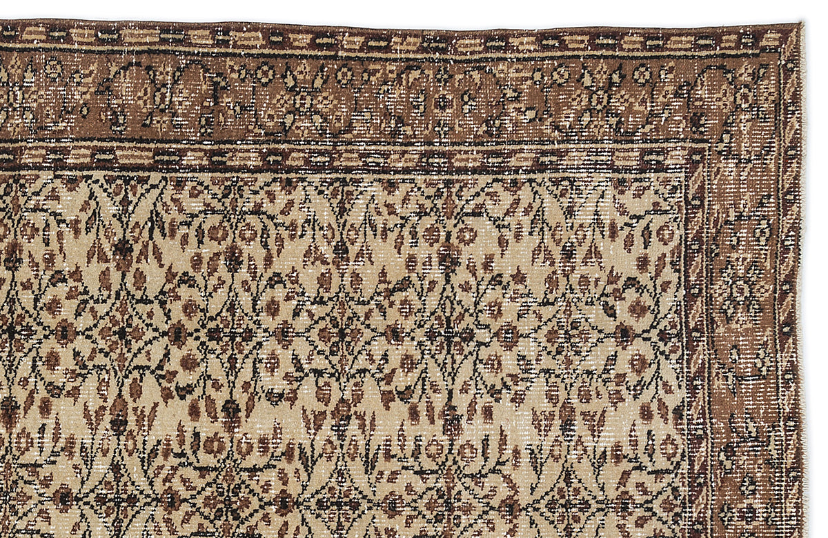 Beige and brown traditional rug with a distressed floral vine pattern and a wide, ornate border.