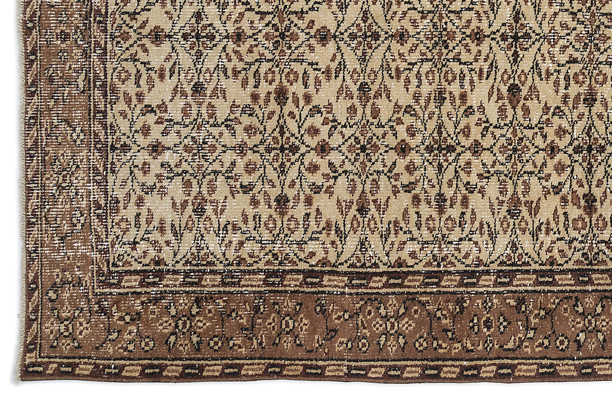 Beige and brown traditional rug with a dense floral medallion pattern and a wide, ornate border.