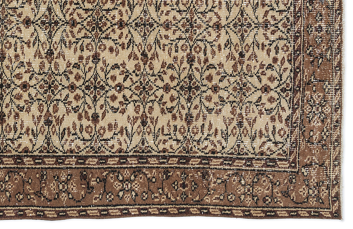 Beige and brown rug with a distressed traditional floral pattern and a wide decorative border.