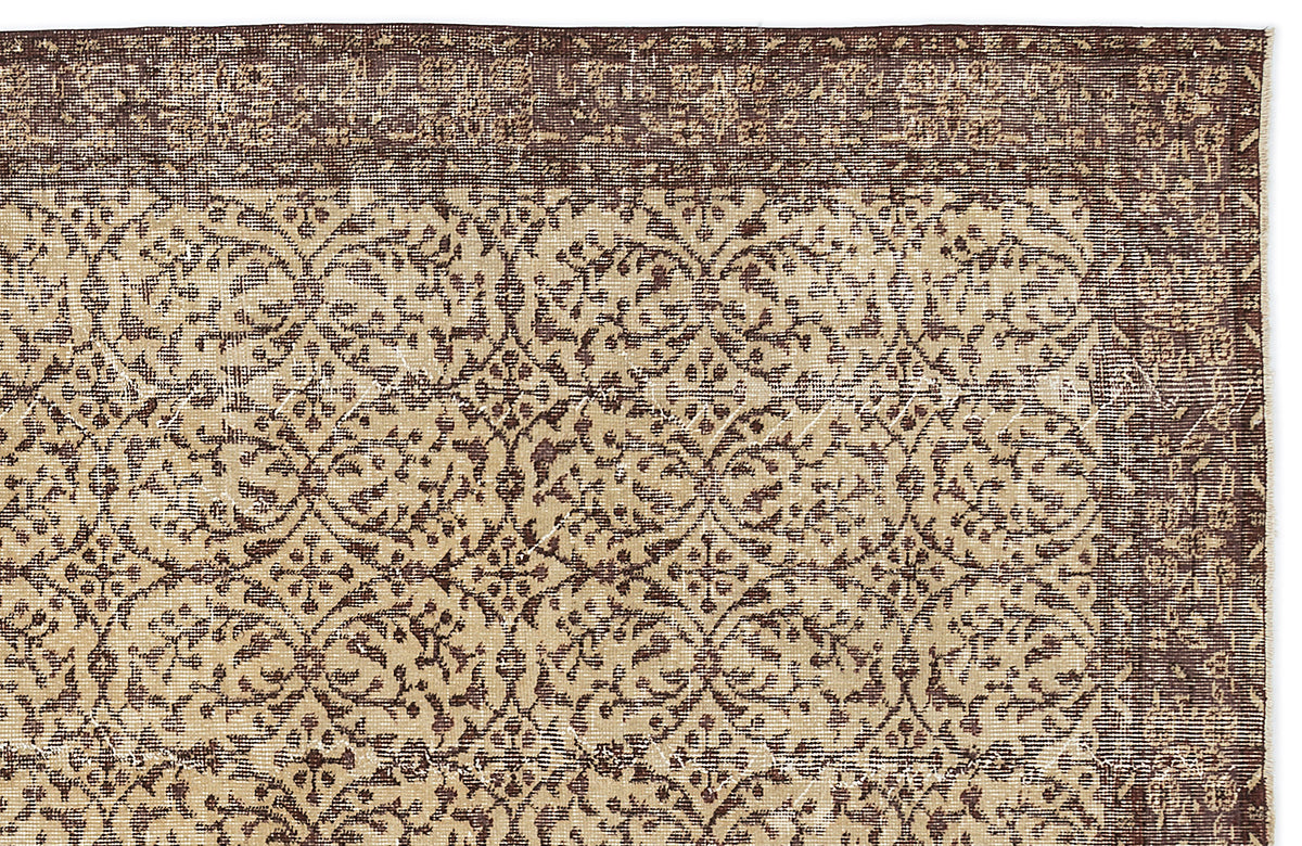 Dark brown and beige rug with a distressed, repeating floral medallion pattern and a wide decorative border.