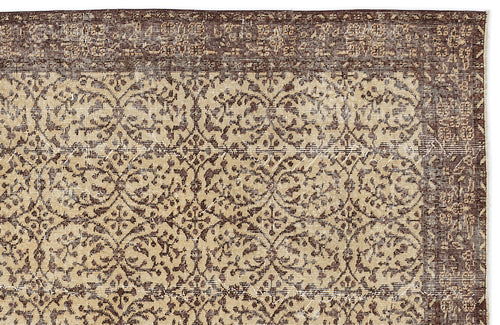 Load image 1 in gallery view. Dark brown and beige rug with a distressed, repeating floral medallion pattern and a wide decorative border.