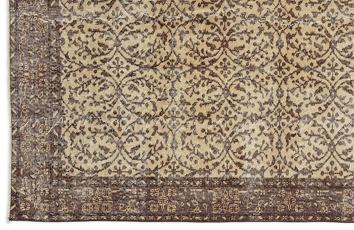 Dark brown and beige rug with a distressed, repeating floral medallion pattern and a wide decorative border.