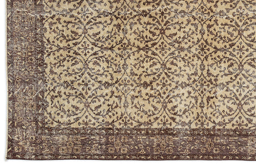 Load image 1 in gallery view. Dark brown and beige rug with a distressed, repeating floral medallion pattern and a wide decorative border.