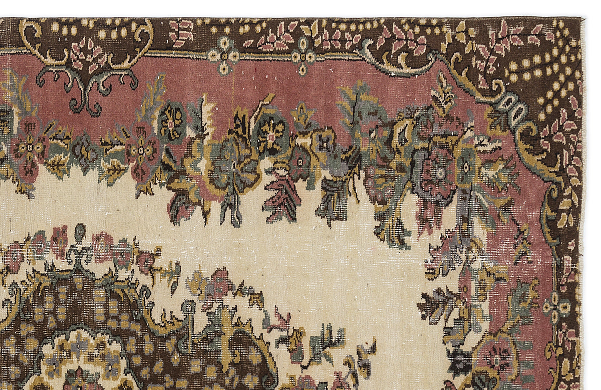 Distressed traditional rug with a floral medallion pattern in muted brown, dusty rose, and cream.