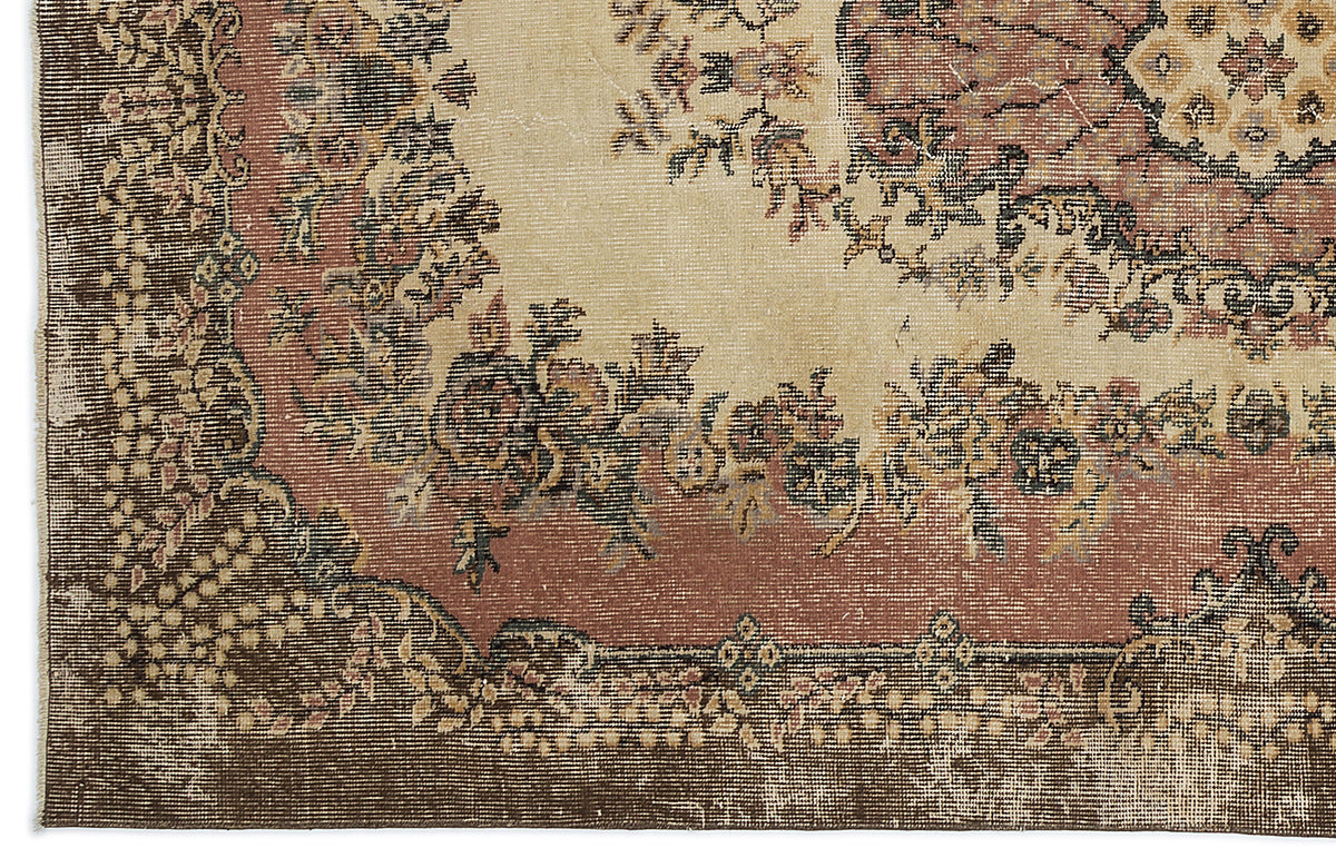 Distressed traditional rug with a cream center, terracotta border, and dark brown floral medallion patterns.