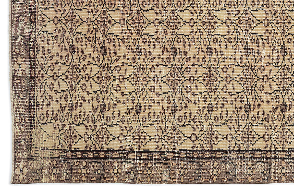 Beige and dark brown vintage-style rug with a distressed floral lattice pattern and a wide geometric border.