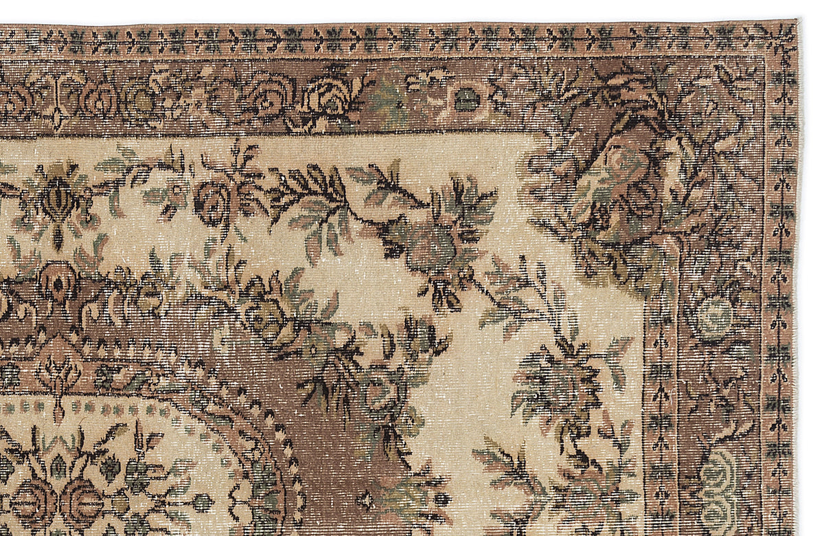 Beige and brown traditional rug with a distressed floral medallion pattern and ornate border.