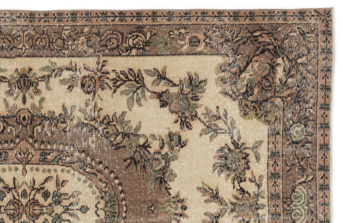 Load image 1 in gallery view. Beige and brown traditional rug with a distressed floral medallion pattern and ornate border.