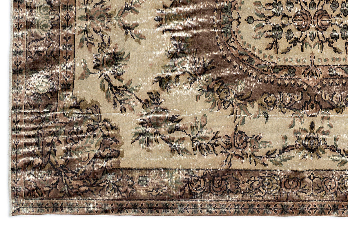 Distressed beige rug with a brown floral medallion and ornate border in a traditional Persian style.
