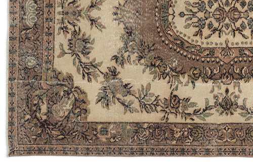 Load image 1 in gallery view. Distressed beige rug with a brown floral medallion and ornate border in a traditional Persian style.