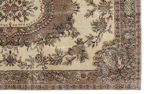 Load image 1 in gallery view. Distressed beige rug with a brown floral medallion and vine border pattern on a white background.