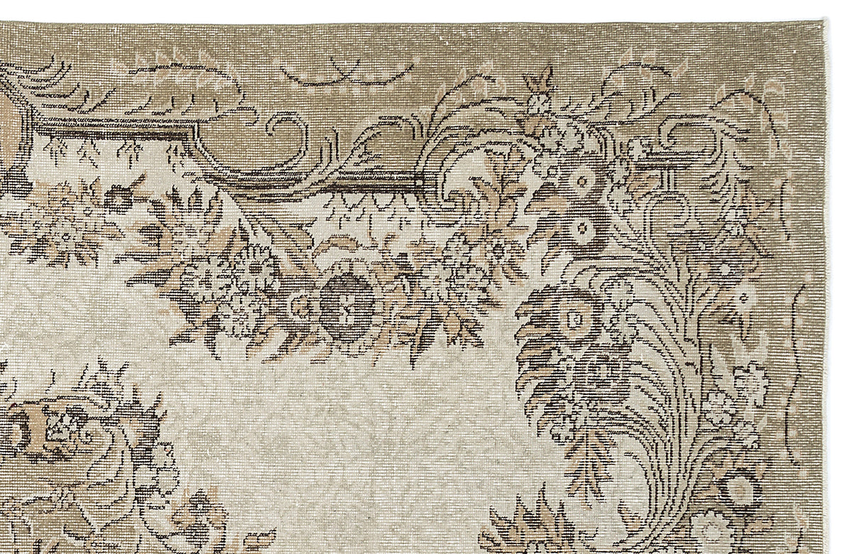 Taupe and cream rug with a distressed traditional floral medallion pattern and ornate border.