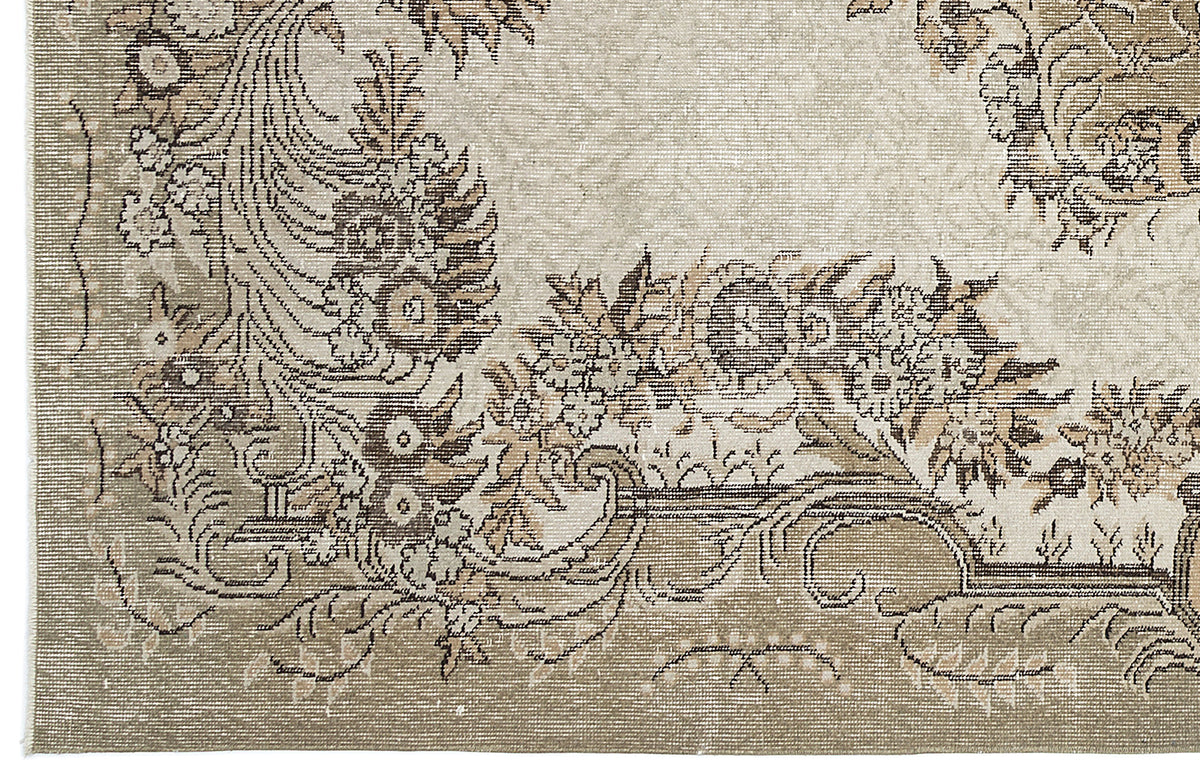 Beige and taupe traditional rug with a distressed floral medallion pattern and intricate border detail.