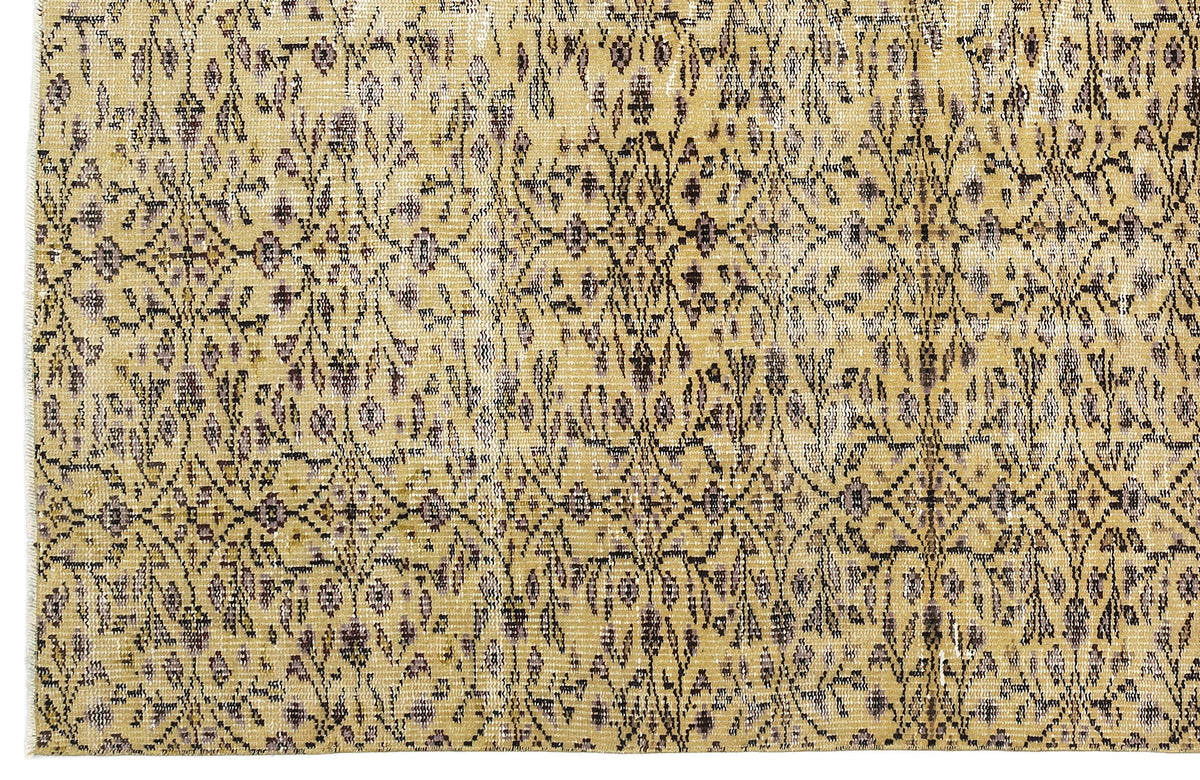Mustard yellow and charcoal grey rug with a distressed, repeating floral medallion pattern.
