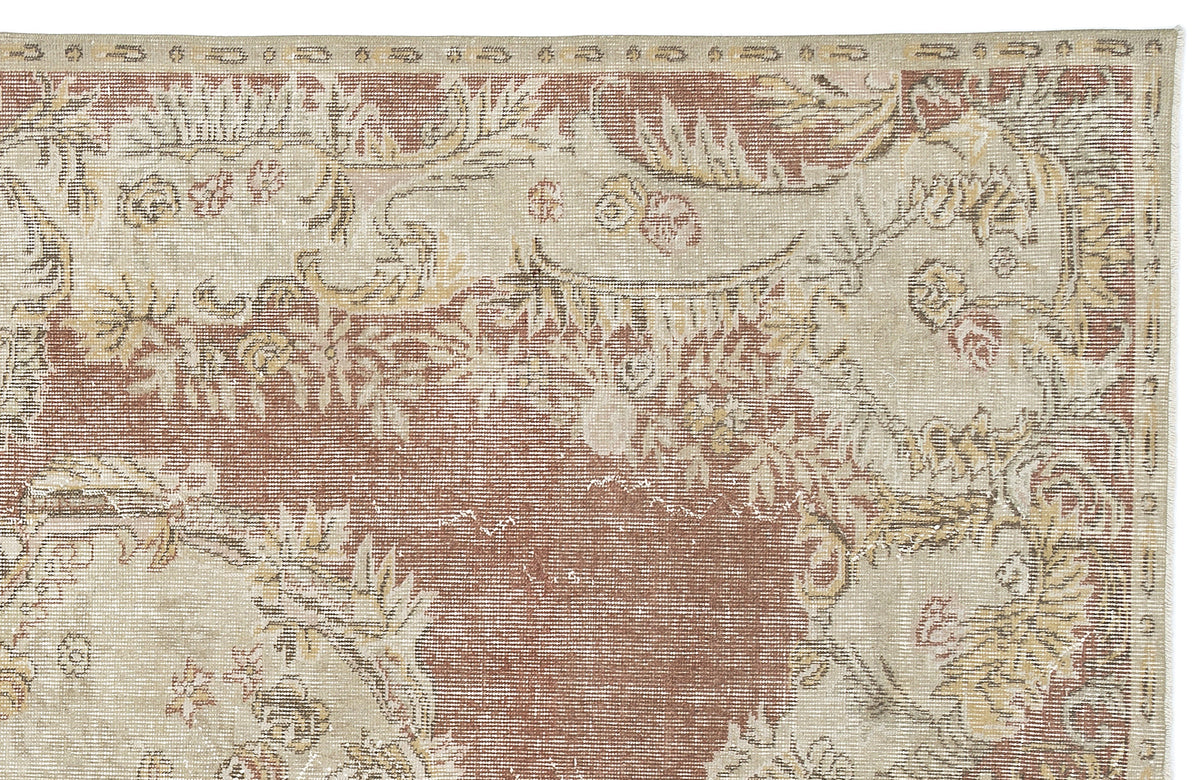 Distressed terracotta and beige rug with a traditional floral medallion pattern and ornate border.