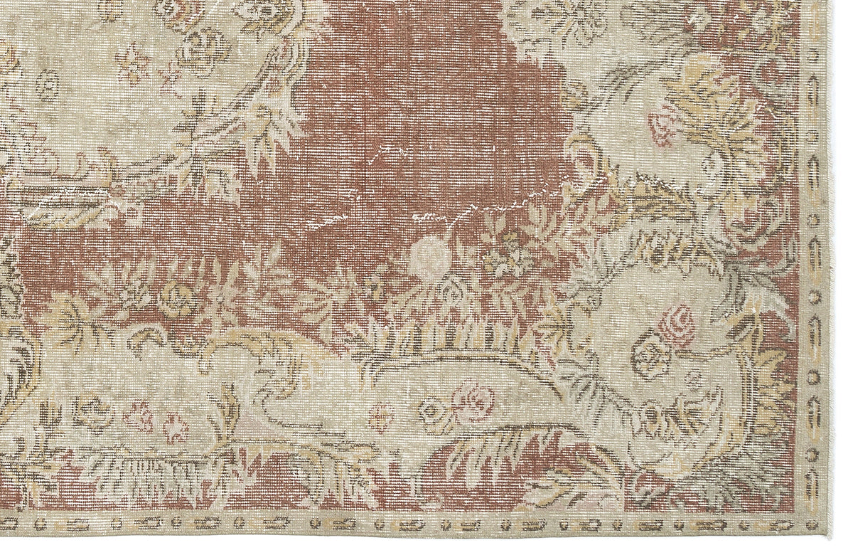 Distressed terracotta and beige rug with a traditional floral medallion pattern and a decorative border.