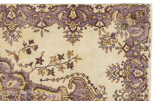 Load image 1 in gallery view. Beige rug with a purple and gold floral border and scattered botanical motifs.