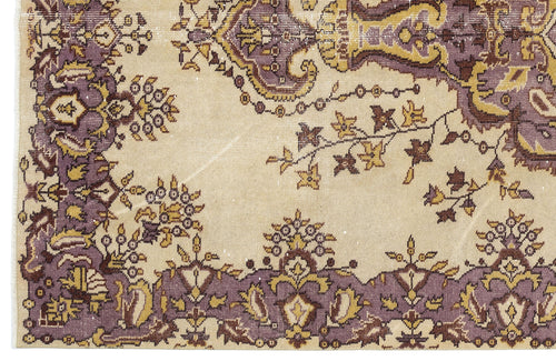 Load image 1 in gallery view. Beige rug with a distressed purple and mustard yellow floral medallion pattern.