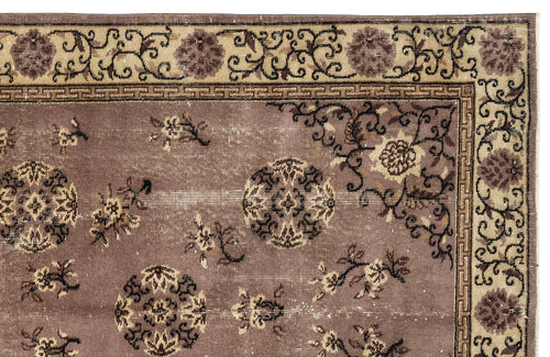 Load image 1 in gallery view. Mauve and beige rug with a distressed floral medallion pattern and a Greek key border.