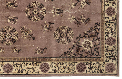 Load image 1 in gallery view. Mauve rug with dark brown circular medallions, floral motifs, and a cream-colored border with a geometric Greek key pattern.