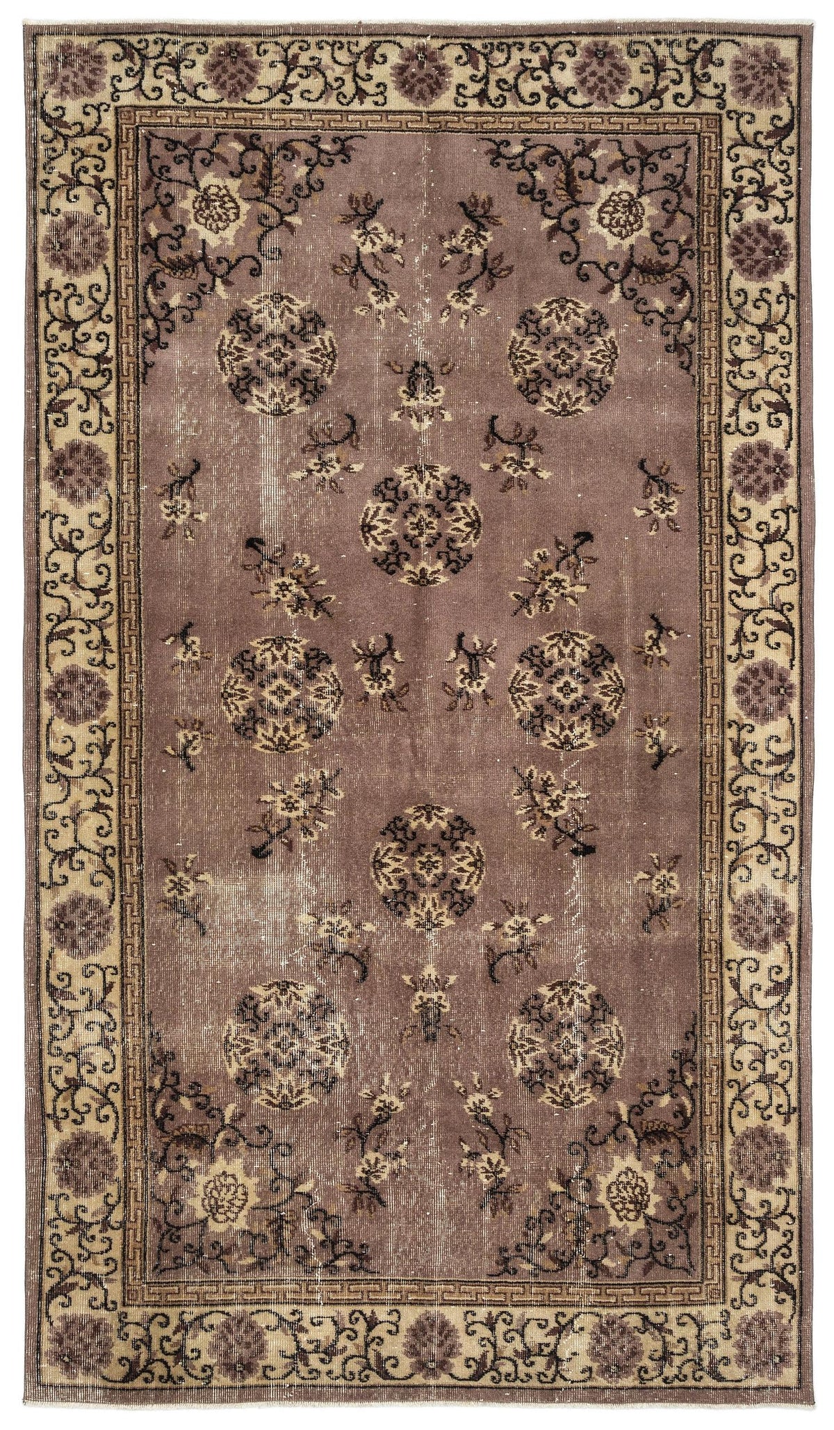 Mauve vintage-style rug with dark brown circular medallions, floral motifs, and a geometric border on a white background.