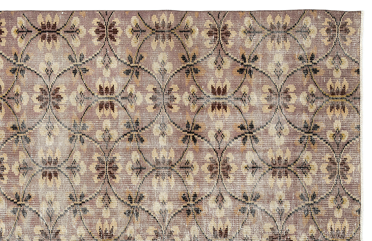 Mauve and beige rug with a repeating dark brown lattice pattern and floral motifs.
