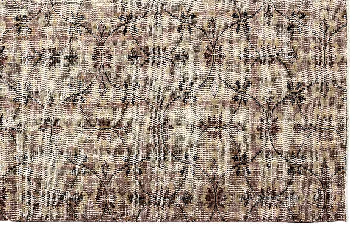 Taupe and beige rug with a repeating dark brown lattice pattern and floral motifs.