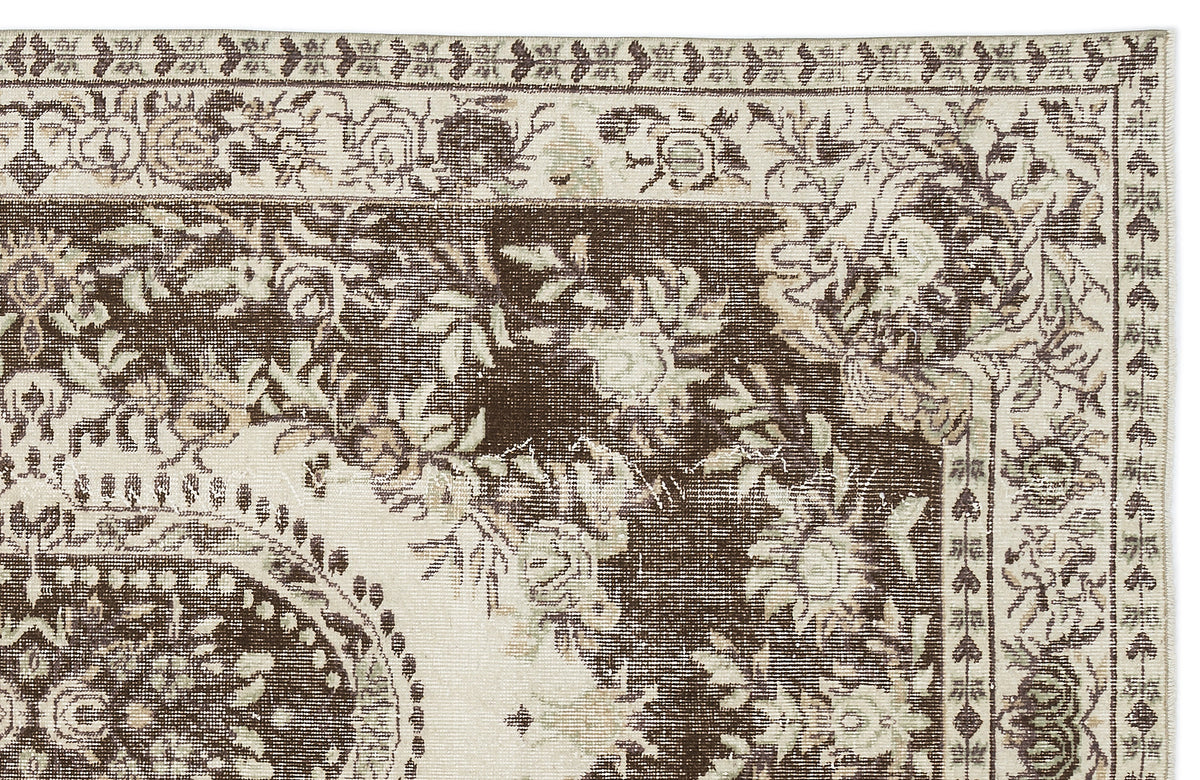 Dark brown and cream traditional rug with a distressed floral medallion pattern and ornate border.